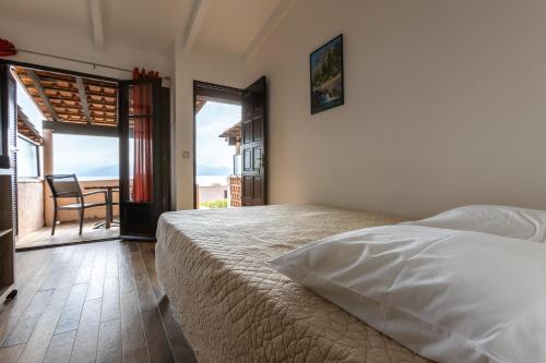 a bedroom with a bed and a view of the ocean at La Punta Geronimi in Porto Pollo