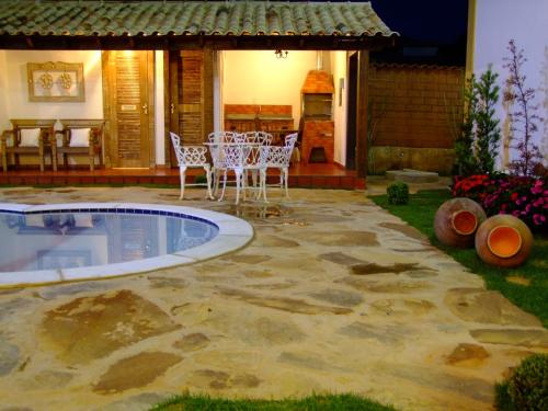 a patio with a table and chairs next to a pool at Pousada Ouro de Minas in Tiradentes