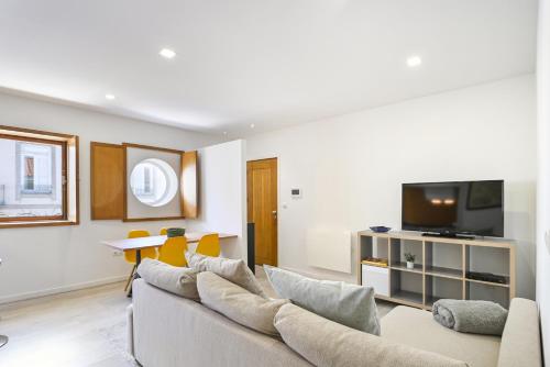 a living room with a couch and a tv at Apartamento familiar no centro histórico - Afonso Henriques in Braga