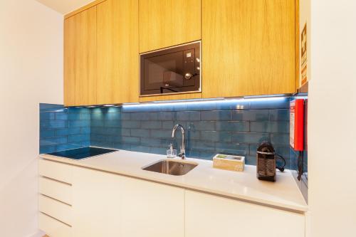 a kitchen with a sink and a microwave at Avenida Residence in Braga