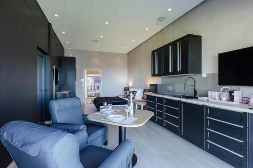 a kitchen with blue chairs and a table in a room at Domaine du Grand Bec in Villerville
