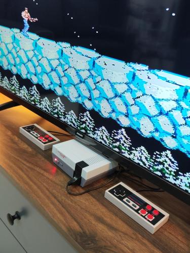 a television screen with a video game console and controllers at Ipoh Lake View Cozy Home Big House in Lahat