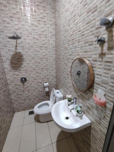 a bathroom with a toilet and a sink and a mirror at Ipoh Lake View Cozy Home Big House in Lahat