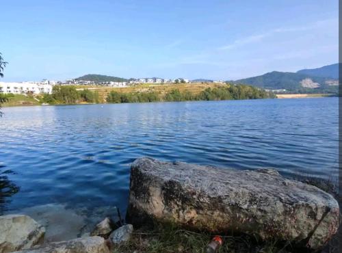 a large rock sitting on the shore of a lake at Ipoh Lake View Cozy Home Big House in Lahat
