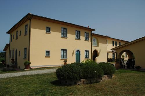 a large yellow building with a green door at Agriturismo Musignano in Cerreto Guidi