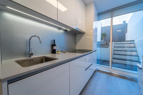uma cozinha com um lavatório e uma janela em Casa Azul em Braga