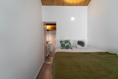 ein Schlafzimmer mit einem großen Bett in einer weißen Wand in der Unterkunft Casa Azul in Braga