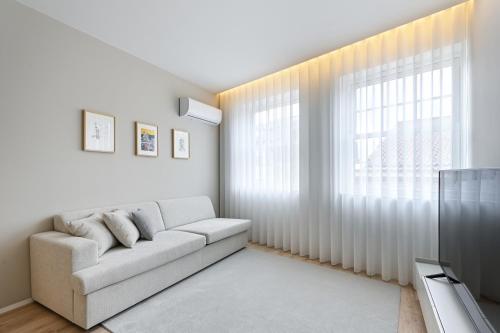 a living room with a couch and a window at Casa da Boavista By Sé Apartamentos in Braga
