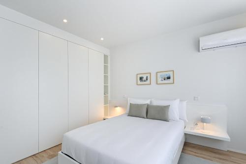 a white bedroom with a large bed and white walls at Casa da Boavista By Sé Apartamentos in Braga