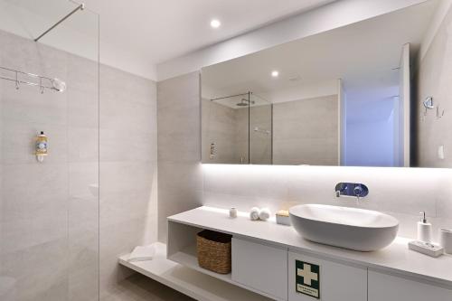 a white bathroom with a sink and a mirror at Casa da Boavista By Sé Apartamentos in Braga