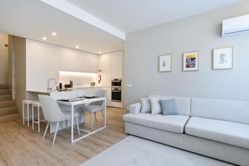 a living room with a couch and a table and a kitchen at Casa da Boavista By Sé Apartamentos in Braga