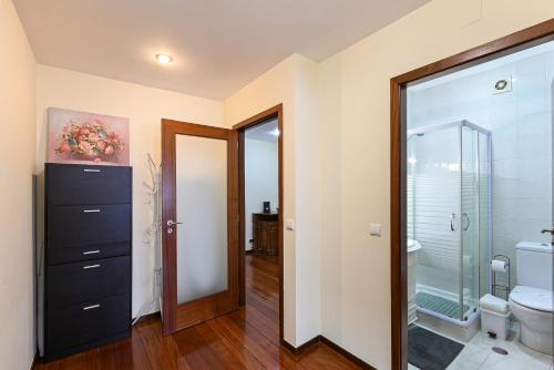 a bathroom with a toilet and a glass door at Sé Apartamentos - Casa Cecília in Braga