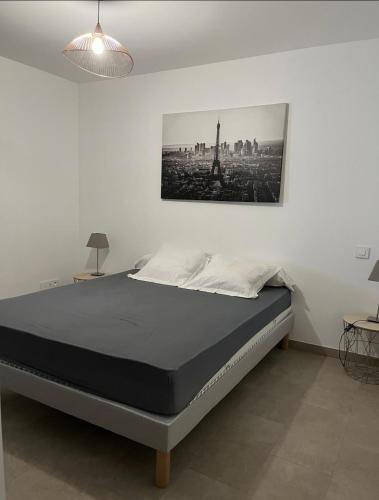 un lit dans une chambre avec un tableau sur le mur dans l'établissement appartement F2 PORTICCIO Proche plage, à Albitreccia