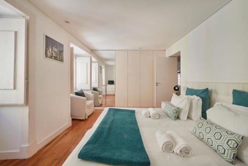 里斯本的住宿－卡拉利茲葡萄牙公寓，卧室配有一张白色大床和绿色地毯