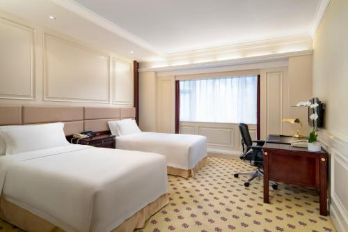 a hotel room with two beds and a desk at Crowne Plaza Hotel & Suites Landmark Shenzhen by IHG - Nearby Luohu Border, Indoor heated swimming pool, Complimentary Welcome Drink in Shenzhen