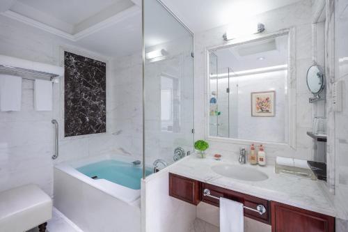 a white bathroom with a tub and a sink at Crowne Plaza Hotel & Suites Landmark Shenzhen by IHG - Nearby Luohu Border, Indoor heated swimming pool, Complimentary Welcome Drink in Shenzhen