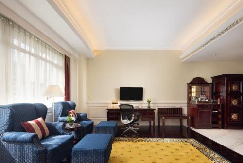 a living room with blue chairs and a television at Crowne Plaza Hotel & Suites Landmark Shenzhen by IHG - Nearby Luohu Border, Indoor heated swimming pool, Complimentary Welcome Drink in Shenzhen