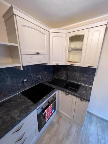 a kitchen with white cabinets and a sink at El Rocol in Vezza dʼOglio