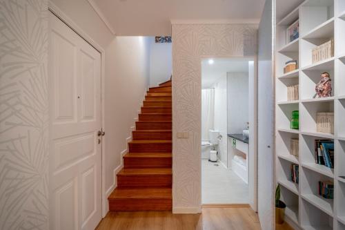 een trap in een huis met houten vloeren en witte muren bij Sé Apartamento - Casa do Chafariz in Braga