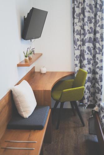 a room with a desk and a chair and a tv at Weingut & Gästehaus zum Seeblick - Familie Sattler in Jois