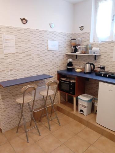 a kitchen with two bar stools and a counter at Bed and Breakfast Stefania in Giulianova