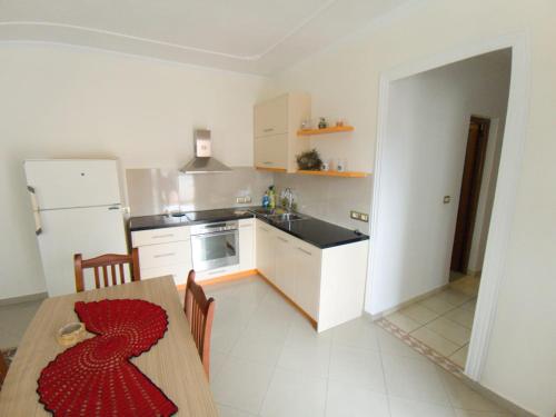 eine Küche mit einem Tisch und einem roten Kleid darauf in der Unterkunft Darius Apartment in Sarandë