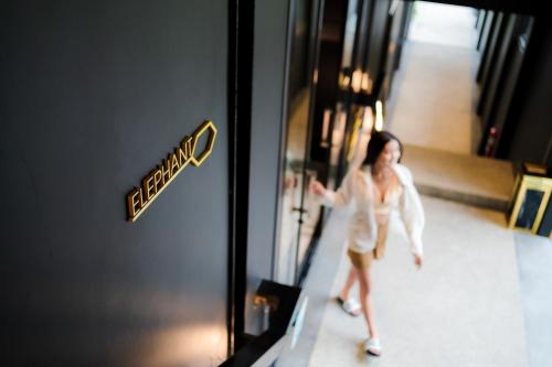 a woman walking in a hallway with a sign on a door at D’Endless Resotel in Baen