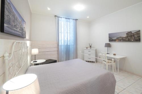 シラクーサにあるSyracuseApartments IL PIAVE di SIRACUSA Appartamento per 6 persone vicino ad ORTIGIA a 200m dal MAREの白いベッドルーム(白いベッド1台、デスク付)