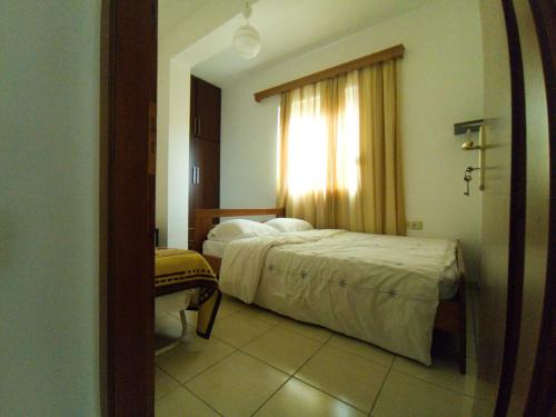 ein Hotelzimmer mit einem Bett und einem Fenster in der Unterkunft Darius Apartment in Sarandë