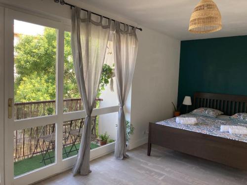 une chambre avec un lit et une grande fenêtre dans l'établissement Cozy Studio with balcony and free parking, à Aix-en-Provence