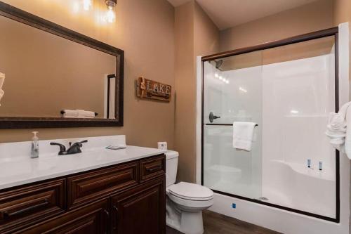 a bathroom with a shower and a toilet and a sink at Staycation Lodge with Indoor Pool and Basketball Court in Branson