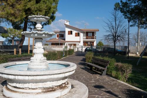 a fountain in a park in front of a house at Bed and Breakfast Villa Alba in Controguerra