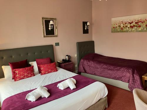 two beds in a hotel room with red pillows at Hôtel de la Côte Fleurie in Deauville
