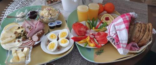 a table with two plates of breakfast foods and drinks at Apartament HELLADA in Krynica Zdrój