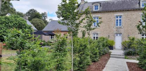 une ancienne maison en briques avec un jardin en face de celle-ci dans l'établissement B&B de charme à 10 minutes de Vannes, à Theix