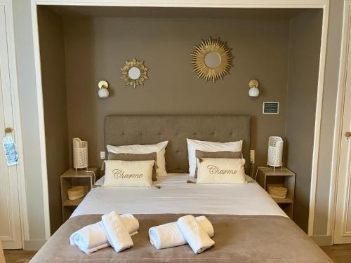 a bedroom with a large bed with two pillows on it at Hôtel de la Côte Fleurie in Deauville