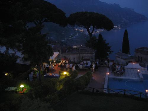 a group of people standing around a patio at night at Villa Casale Ravello Residence in Ravello