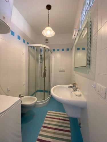 a bathroom with two sinks and a glass shower at SAGGI - 3 posti letto sul mare con posto auto in San Vincenzo