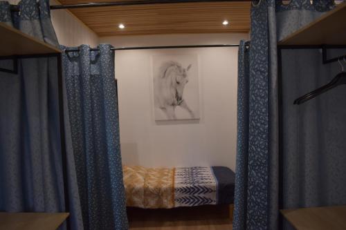 a bedroom with a bed and a picture of a horse at Gîtes du Franc Rosier in Rigny-Ussé