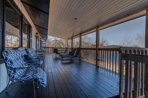a screened in porch with chairs on a deck at Red Bud Cove Lakefront Farm House on Table Rock Lake in Hollister