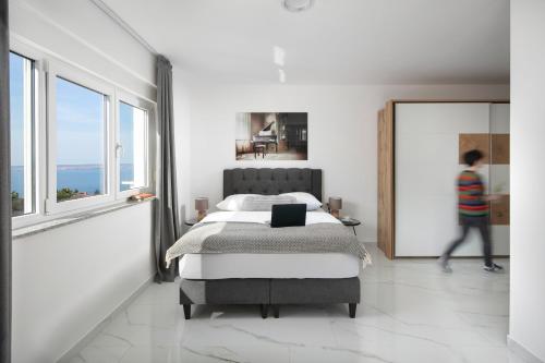 a bedroom with a bed and a person walking in the window at Villa Chanel in Crikvenica