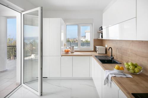 a white kitchen with a sink and a window at Villa Chanel in Crikvenica