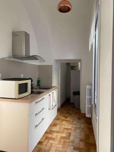 a kitchen with a microwave on top of a counter at Appartement de charme au cœur du centre ville . in Millau