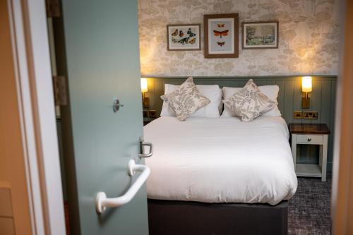 a bedroom with a bed with white sheets and pillows at Ardencaple Hotel by Greene King Inns in Helensburgh