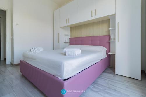 a bedroom with a large bed with a purple headboard at MADREPERLA - SAN FOCA in San Foca