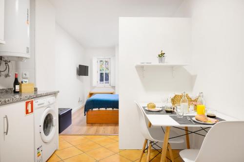 a kitchen and a living room with a table with food on it at Porta 34 Apartments in Braga