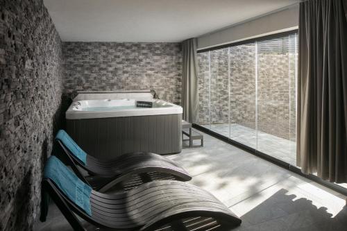 a bathroom with a tub and a large window at Villa Chanel in Crikvenica