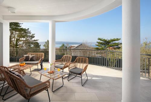 a patio with chairs and tables on a balcony at Villa Chanel in Crikvenica