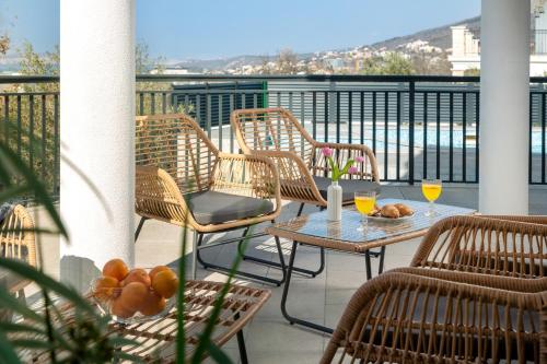 a balcony with chairs and a table with drinks on it at Villa Chanel in Crikvenica