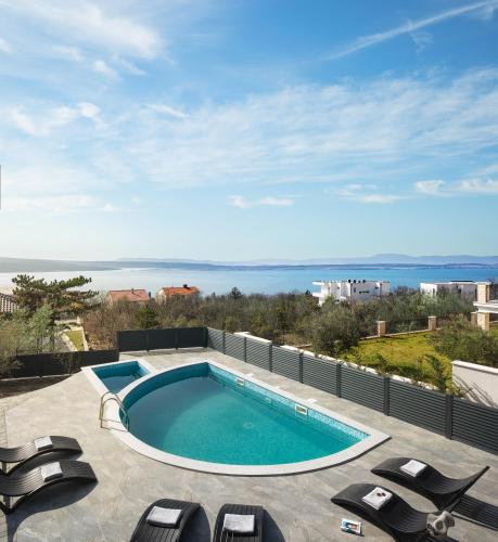 a swimming pool on top of a patio with lounge chairs at Villa Chanel in Crikvenica